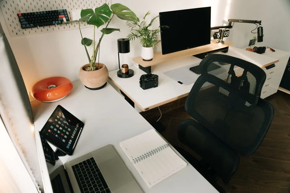 Modern home office desk with a laptop, plants, and tech accessories